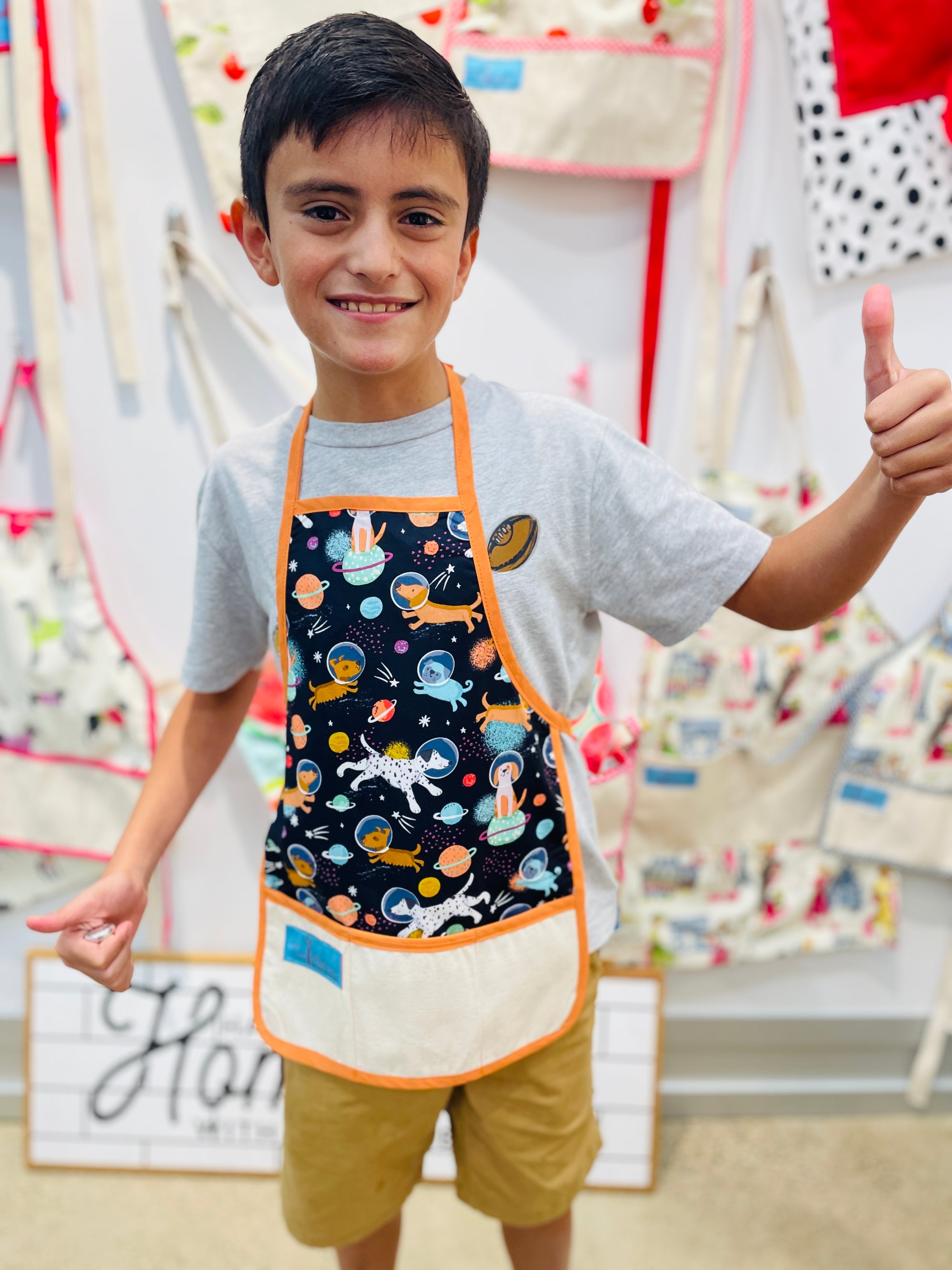 Two Medium Sized Ladies Children's apron space dogs exploration NASA shooting stars planets cosmos worn by little boy aged 10